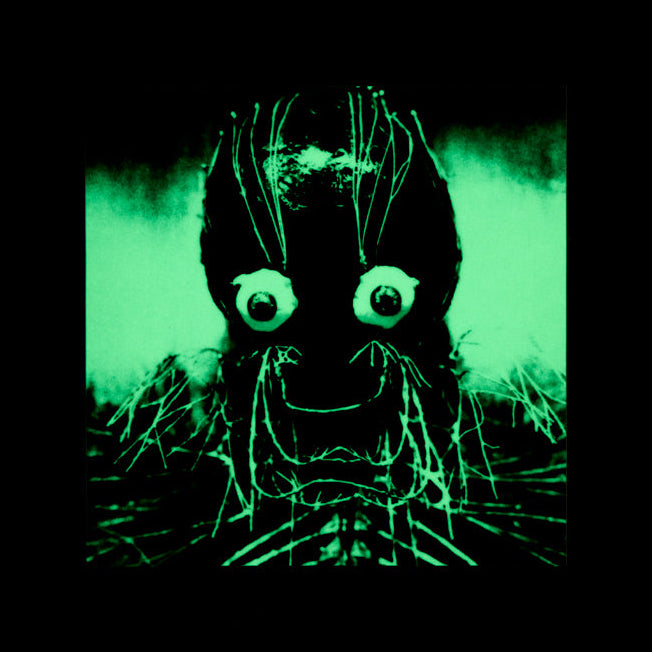 A square graphic print featuring a creepy, horror-style face with large bulging eyes and glowing green lines on a black background, centered within a larger black square.